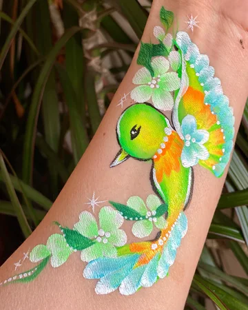 Colibrí multicolor con flores pintado en el brazo