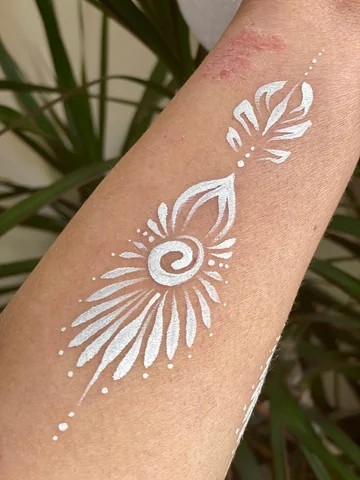 Adorno blanco con espiral y pétalos pintado en el brazo