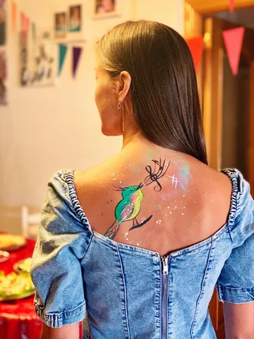 Pájaro verde con notas musicales pintado en la espalda