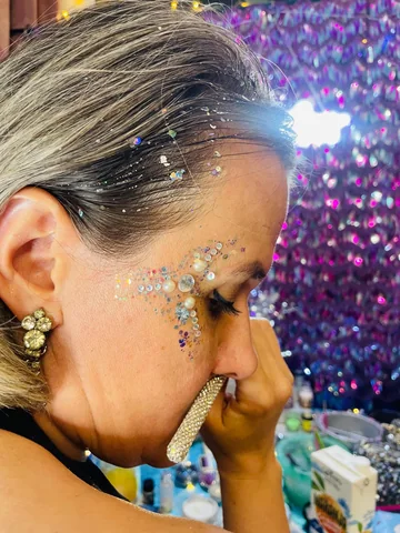 Glitter y cristales en el rostro y el cabello vistos de perfil
