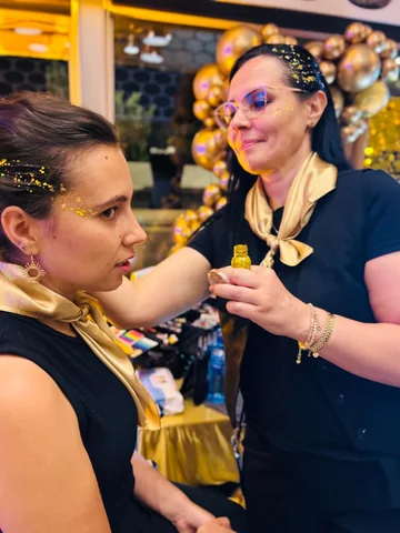 Aplicación de glitter dorado durante un evento