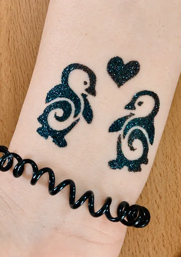 Dos pingüinos de glitter azul oscuro y un corazón