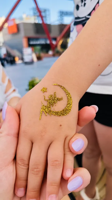 Hada y luna de glitter dorado en la mano
