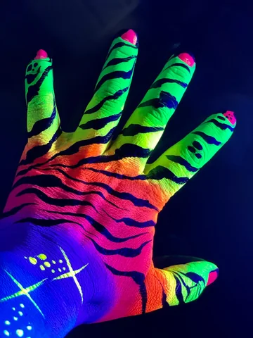 Mano con pintura neón multicolor y rayas oscuras