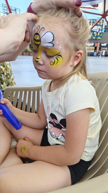 Niña con maquillaje de abeja amarillo y blanco