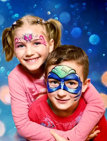 Dos niños con maquillaje de mariposa rosa y héroe azul