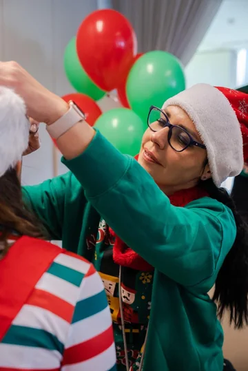 Tati pintando la cara de un niño en un evento navideño