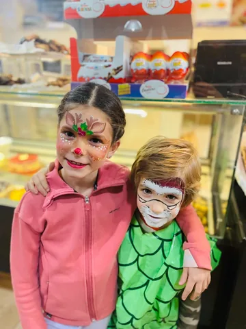 Dos niños con maquillaje de reno navideño y pirata