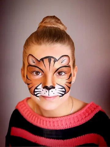 Pintacaras de tigre con rayas negras y colmillos blancos